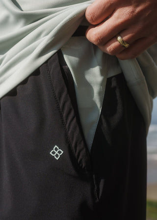 Black and green active shorts featuring an elasticated drawstring waistband.