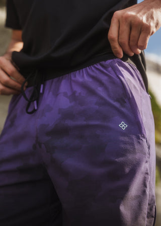 Purple camo active shorts with elastic drawstring waistband and zippered pockets.