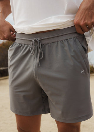 Gray hyper-breathable active shorts with elastic drawstring and zippered pockets for pickleball athleisure.