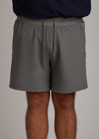 Gray hyper-breathable active shorts with elastic drawstring and zippered pockets for pickleball athleisure.