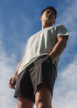 Versatile black and green active shorts with mesh-lined front pockets.
